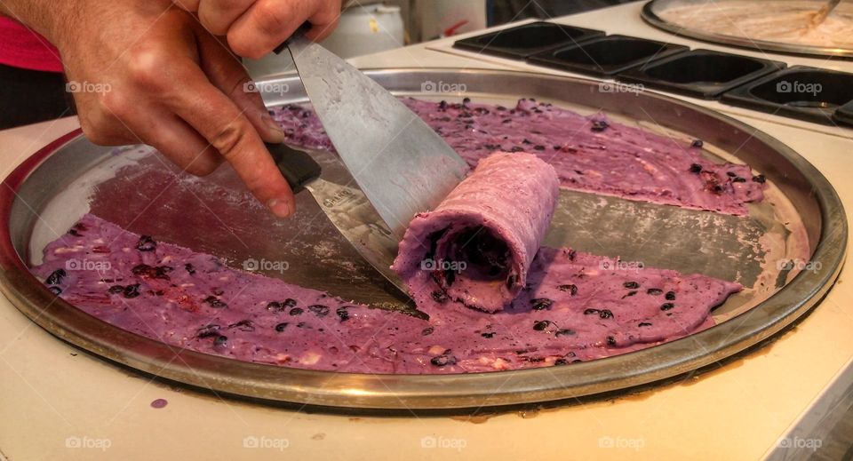 Person hands removing frozen ice cream from plate