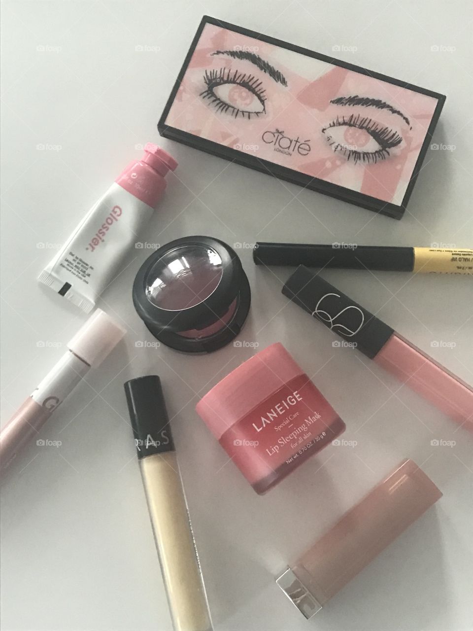 Pink makeup flat lay with multiple eyeshadow products 
