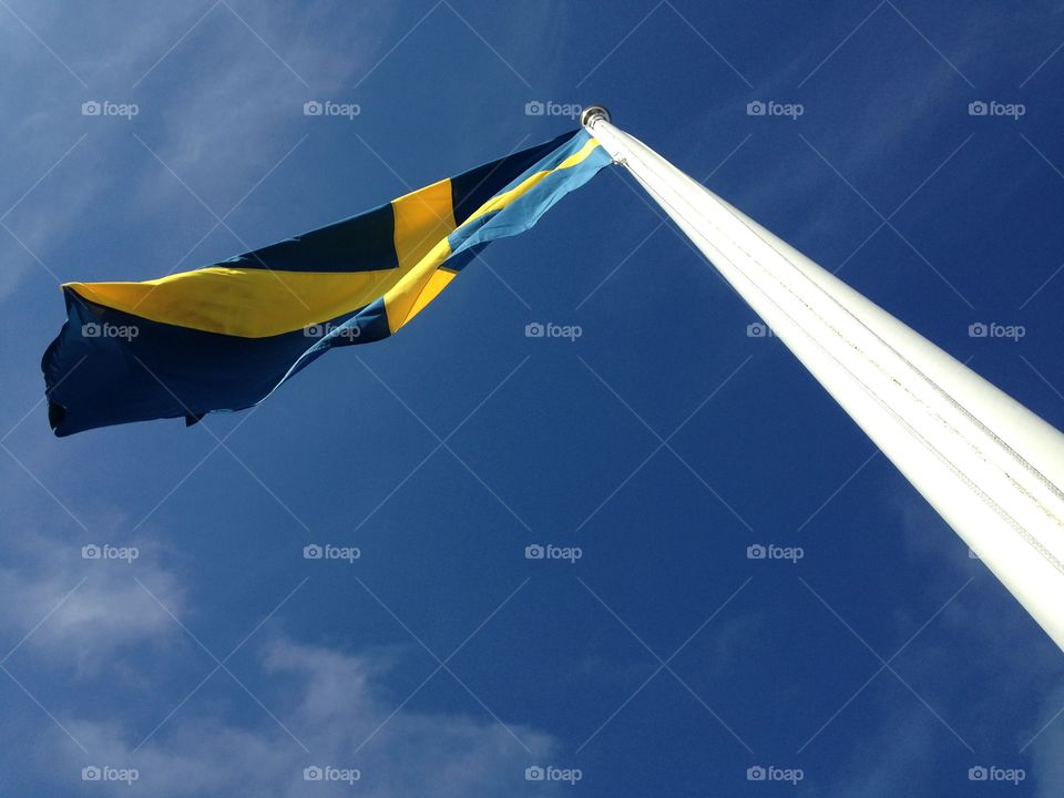 Swedish flag. Seen from below, a Swedish flag and a pure blue sky.