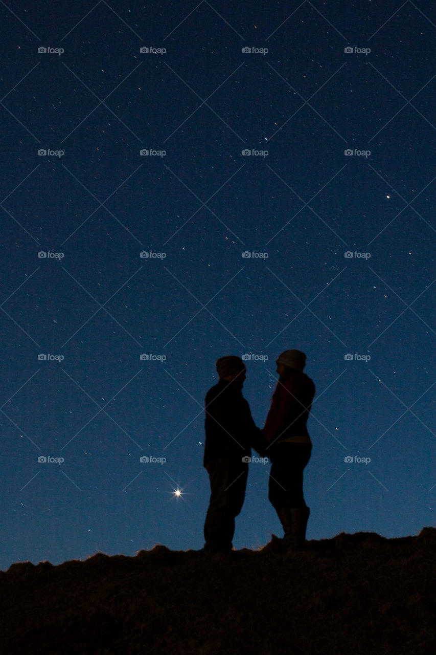 Silhouette of couple holding hands