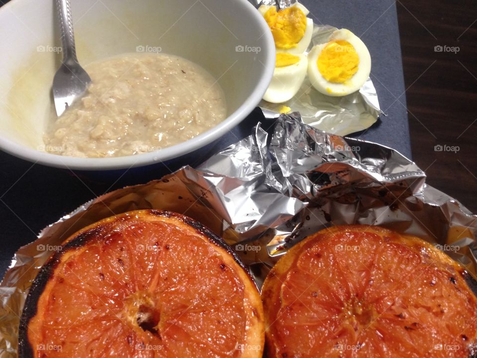 A healthy breakfast. Oatmeal, boiled eggs, broiled grapefruit. 