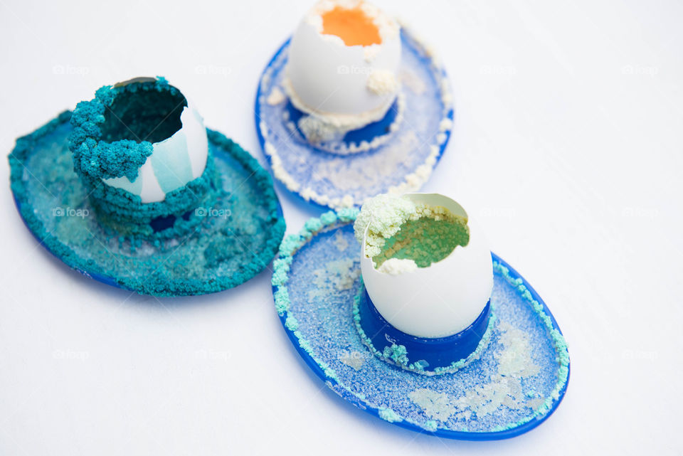 Close-up of a group of three egg shells covered in colored salt crystals