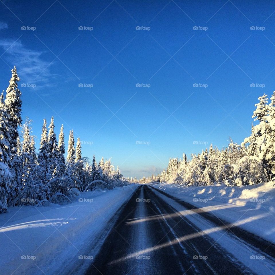 Winter road blue sky Lappland Sweden