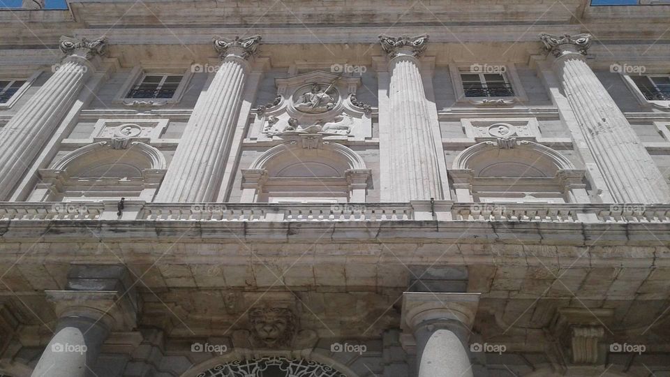 Staring upwards at old building.
White building with pillars and antique architecture.