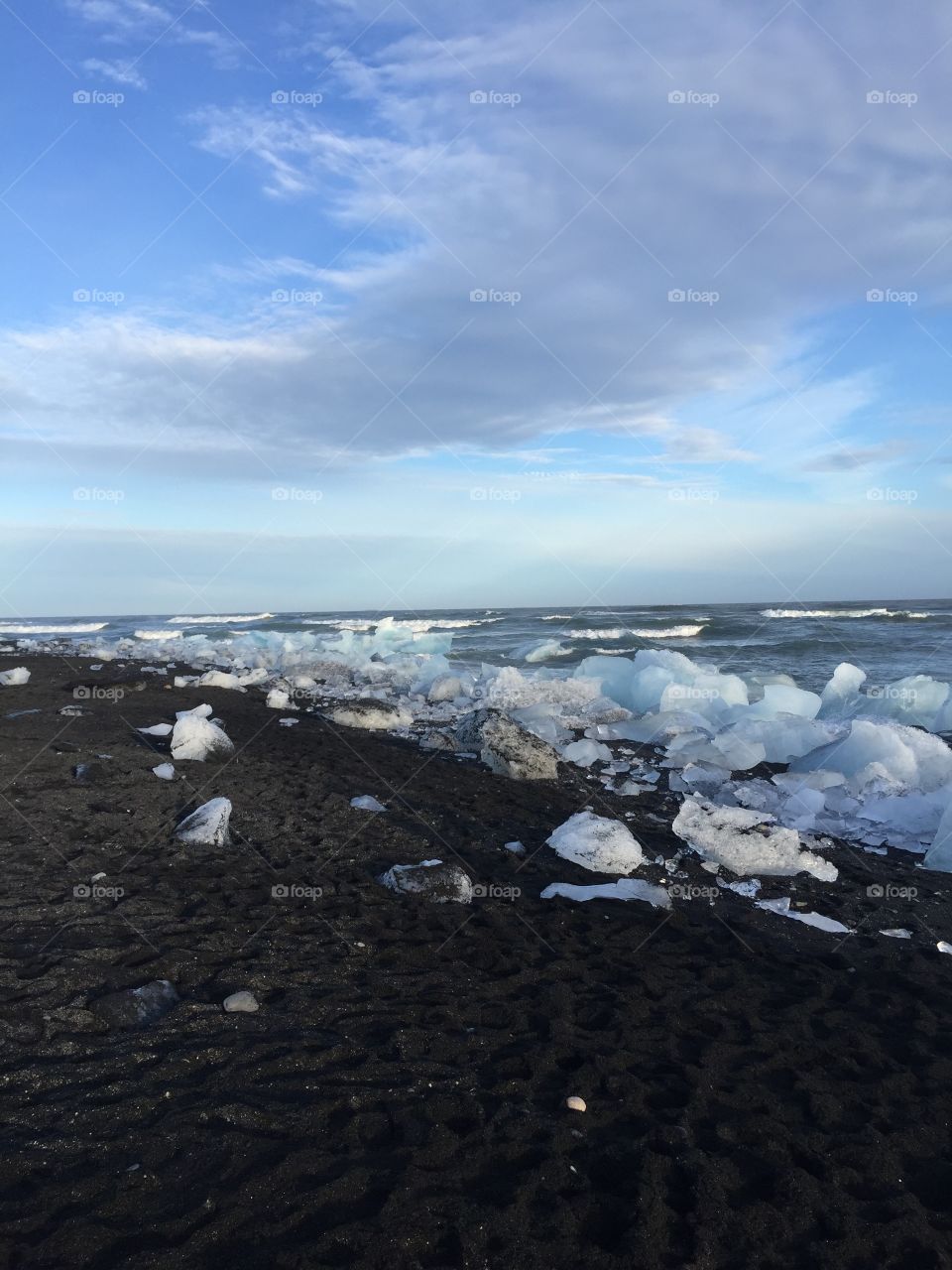 This is a black sand beach in Iceland that has large chunks of glacial ice on the shore. 