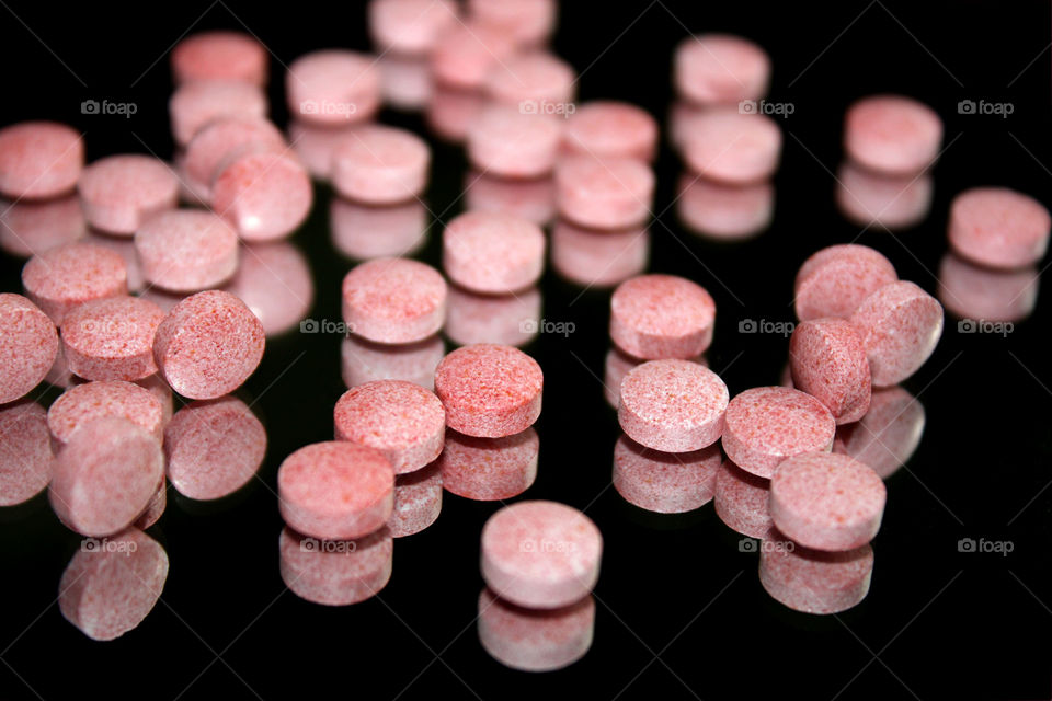 Pink pills, black background