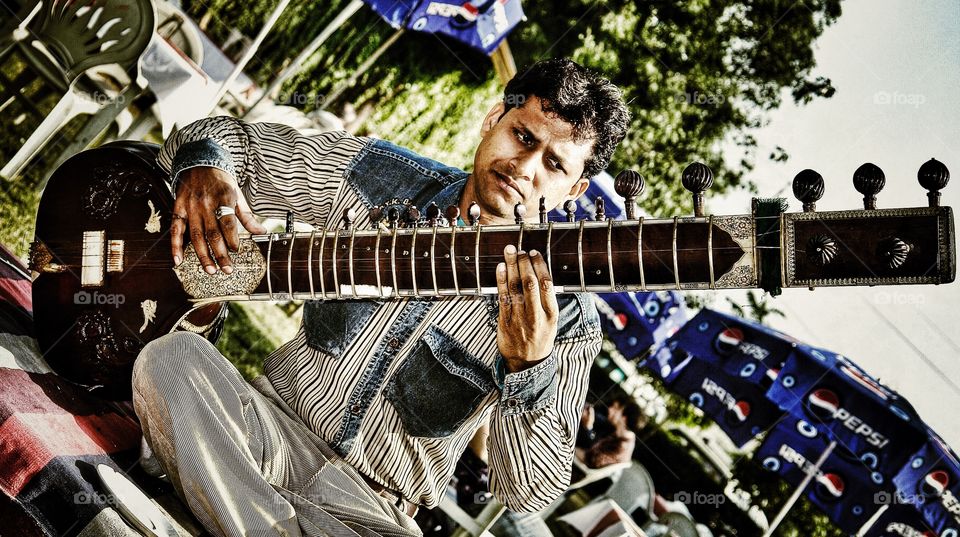 Indian man concentrates as he plays the Sitar, Agra, India . Indian man concentrates as he plays the Sitar, Agra, India 