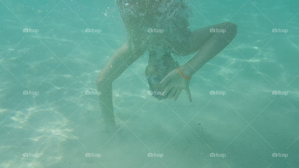 Underwater view of boy with bubbles in a swimming pool