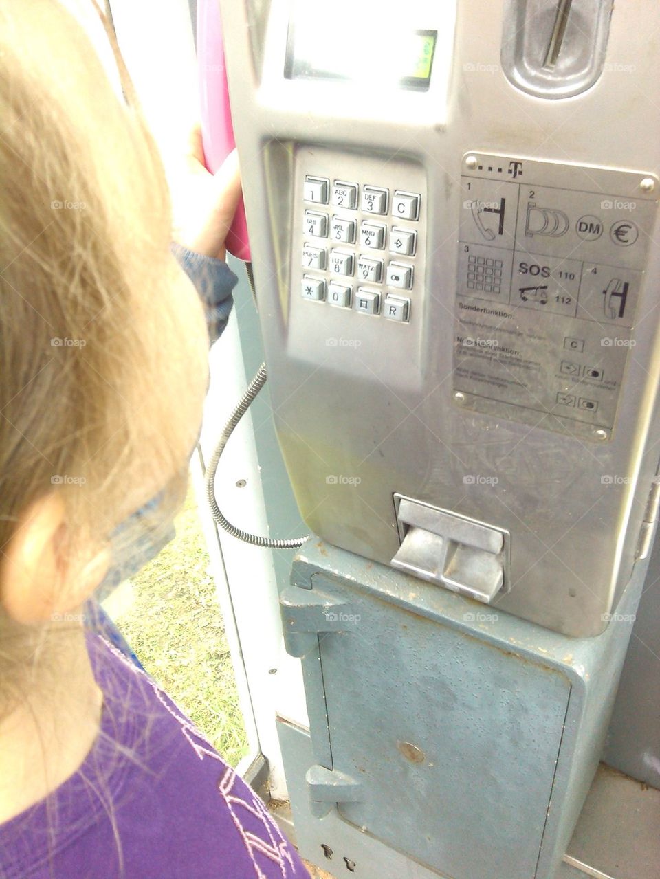 little girl calling with public phone