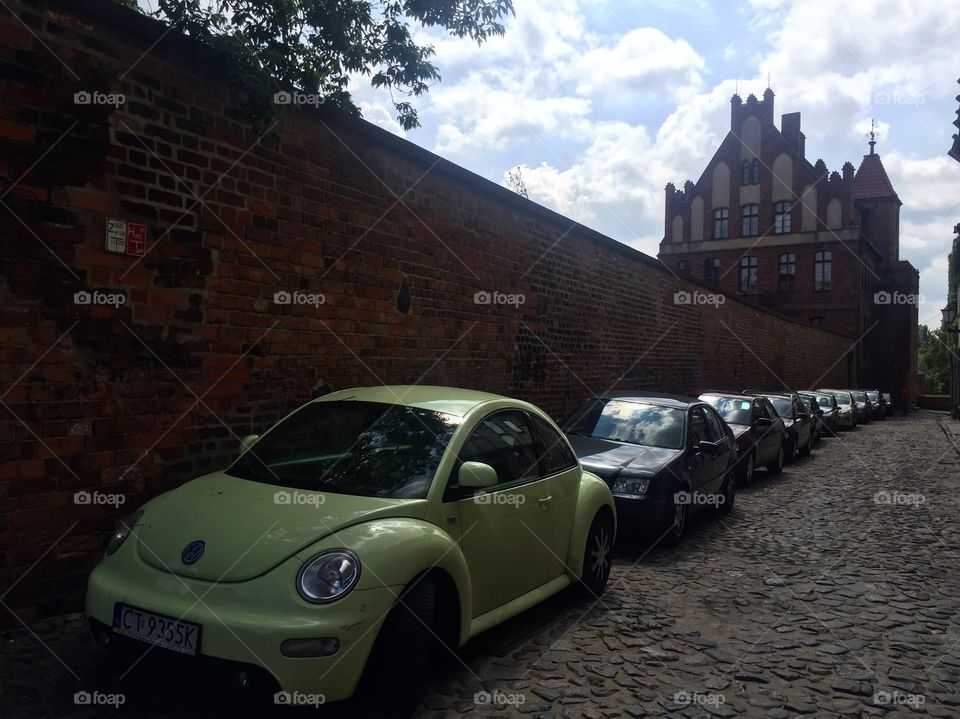 Cars parked near a fortified wall of a castle