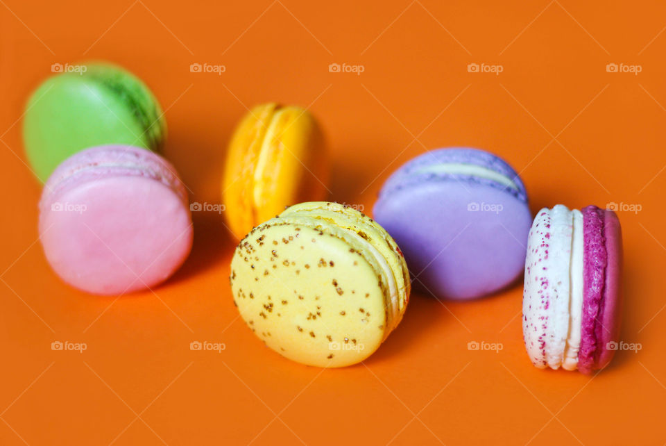 Colorful macaroons dessert on the orange background
