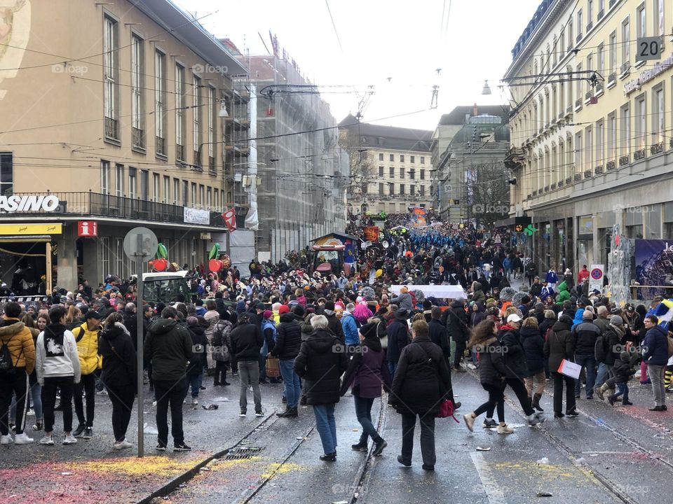 a large crowd of running people in the city among large buildings