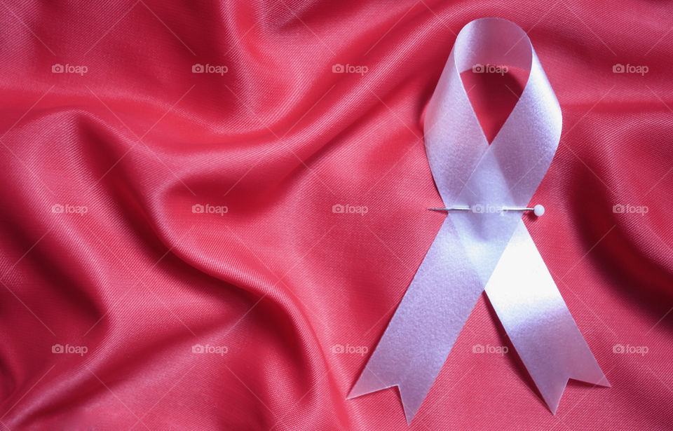 A white ribbon on a pink background