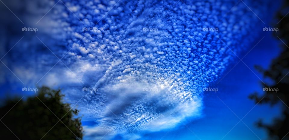 Vivid beautiful blue sky with distinctive cloud pattern. High contrast, saturation and deep tones