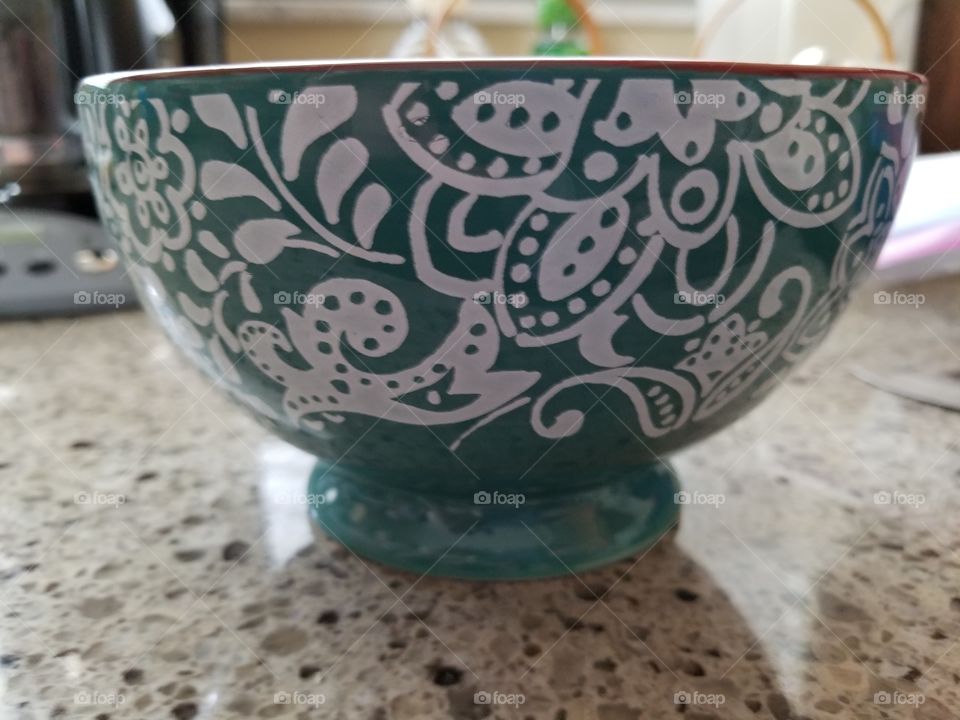 The beautifully green bowl is intricately hand painted with a welcoming design.