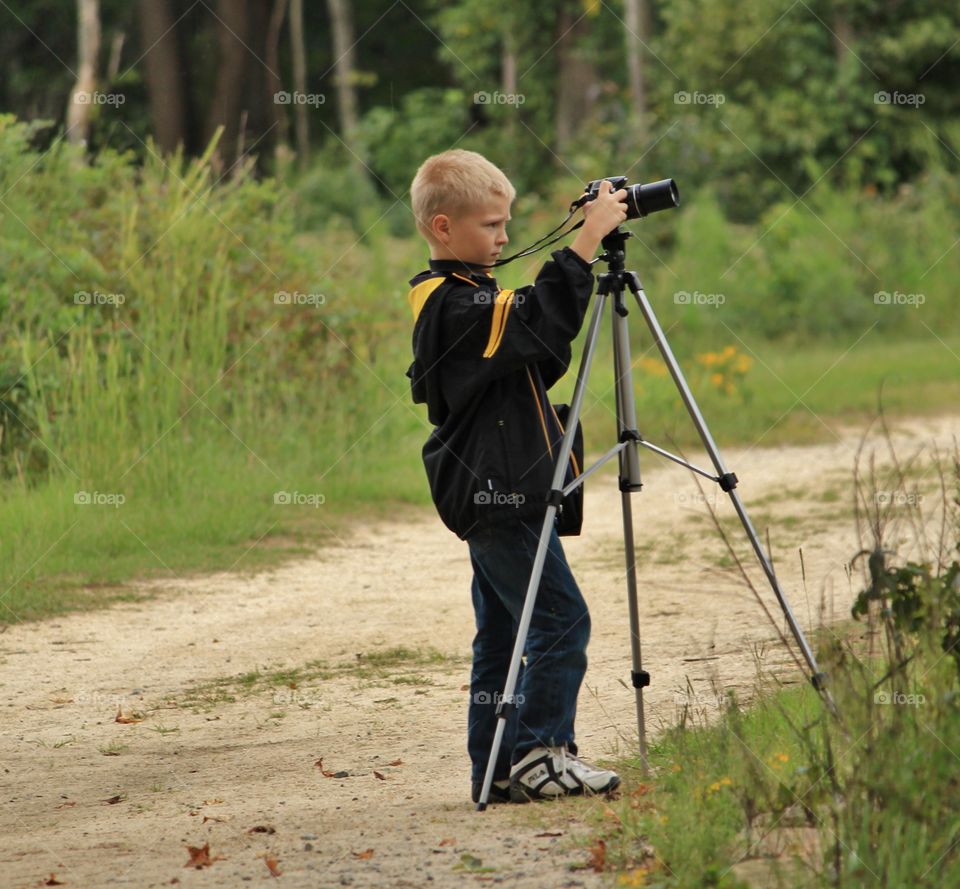 Boy capturing picture in nature
