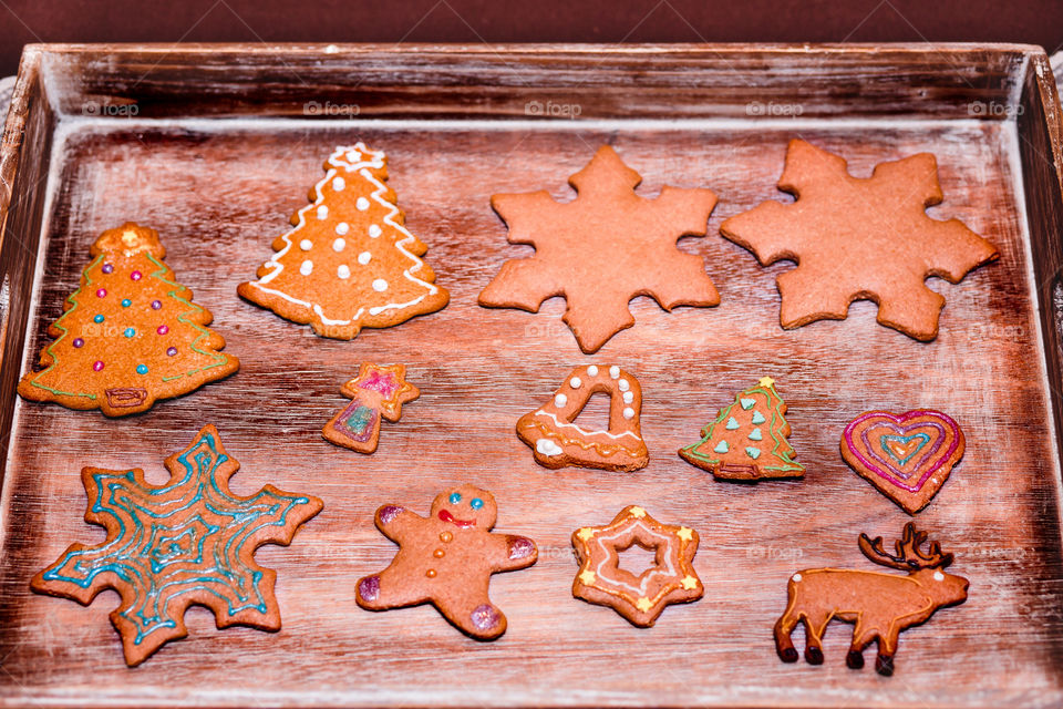 Christmas cookies decorated with frosting on wooden board