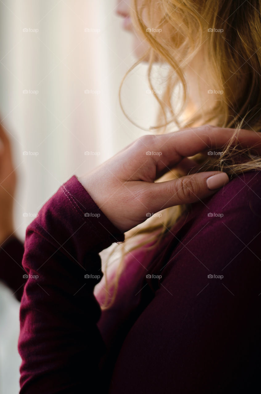 A girl standing next to a window, looking outside. Cold autumn day. Thinking and wishing.