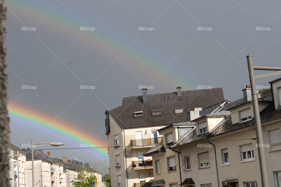 Dark clouds and rain no sight of the sun. Then a band of shining bright colors appears in between the boring dull looking clouds seeks ,the wonderful double rainbow.