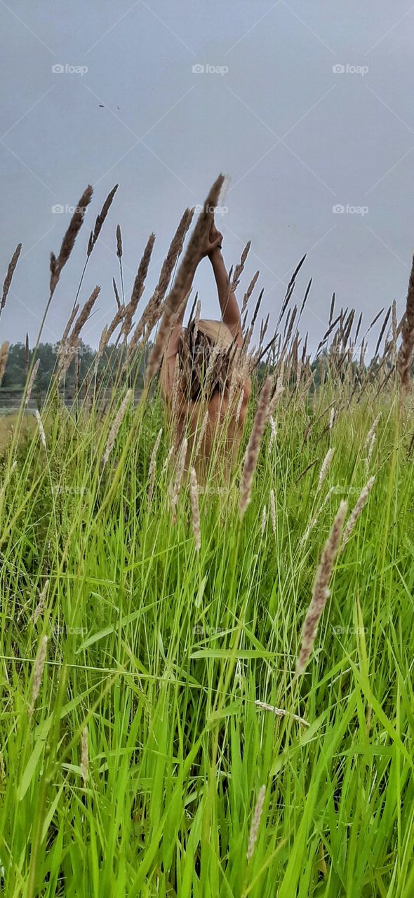 девушка с голой спиной в высокой траве