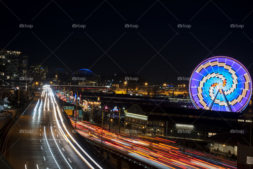 Seattle waterfront long exposure with highway and Ferris wheel at night. 