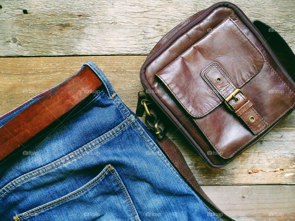 blue jeans with leather belt and leather men's bag