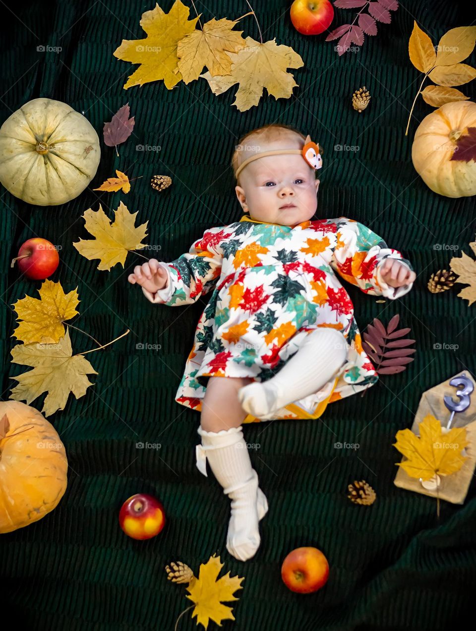 Autumn season top view child little girl in dress lies surrounded by pumpkins