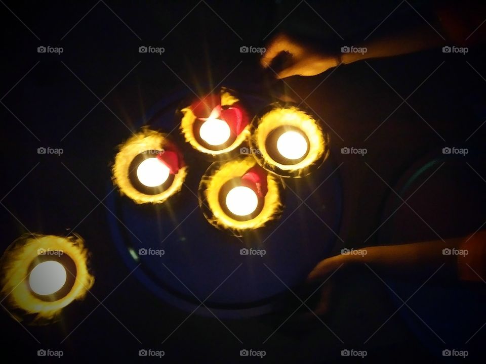 Tray of lighted candles for making wishes at a Diwali festival of lights.