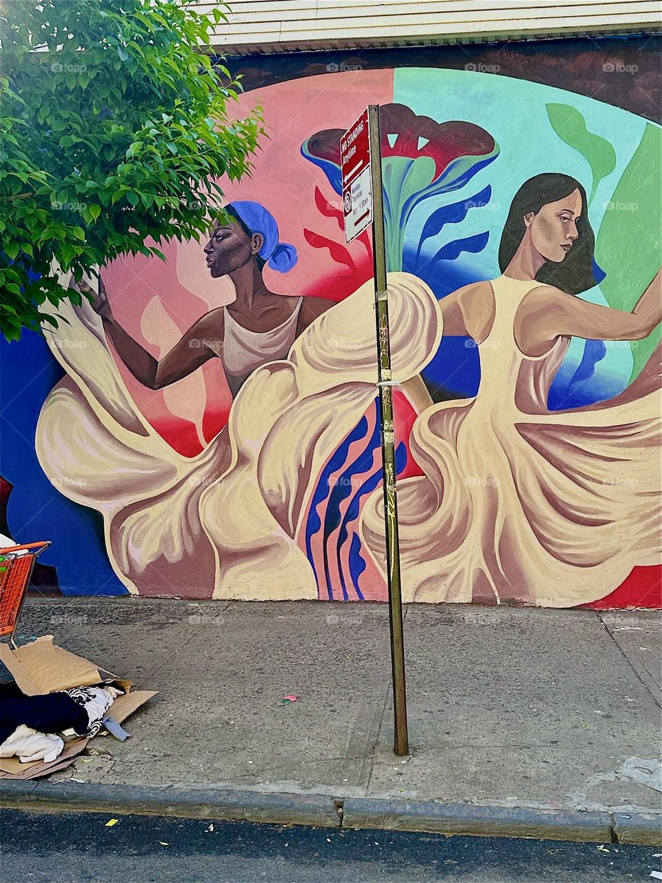 These Latina dancers flaunting their flowing white gowns as they turn and twirl adorn the facade of “Jefferson St” by “B’way” & “Myrtle Ave” in “Bushwick”, Bklyn as part of a mural that is almost an entire city block long. 2024. Hypnotic Productions