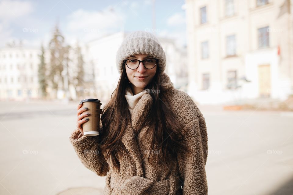 young woman drinking takeaway coffee in the city center