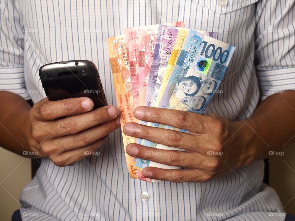 man holding phone and money. man holding phone and bills of money
