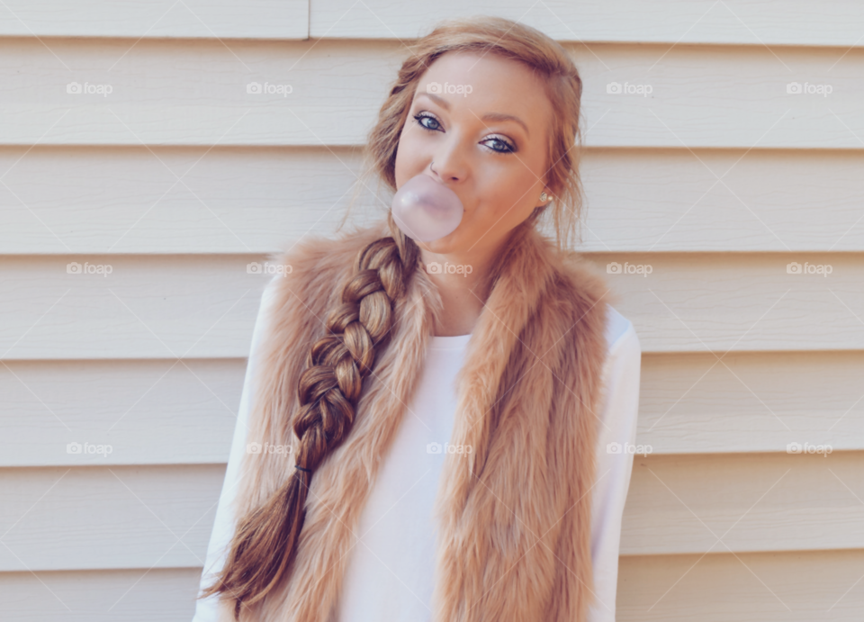Young beautiful woman blowing bubble gum