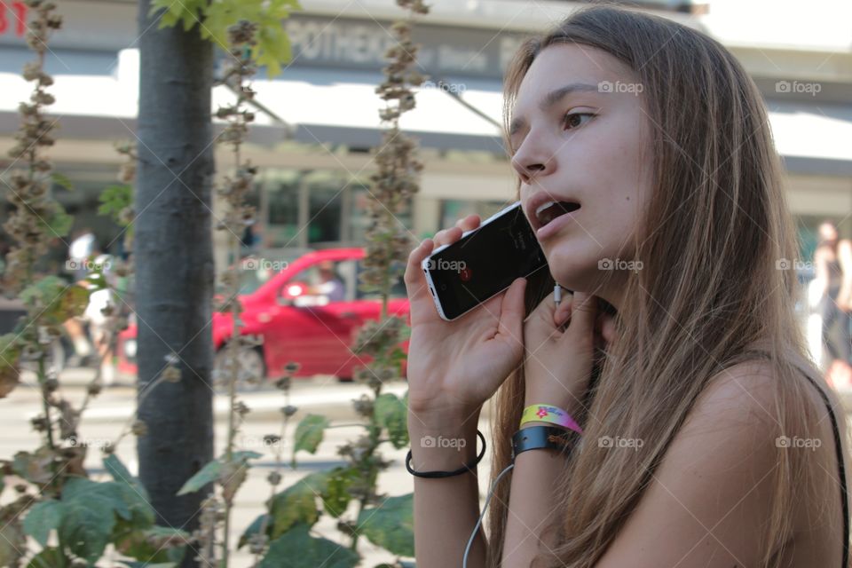 Girl On Phone. Beautiful young girl waking in the street talking on the phone