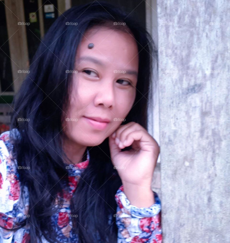 Cilacap, Indonesia-Oktober 17, 2021:the expression of a woman taking selfies with a private camera in the yard