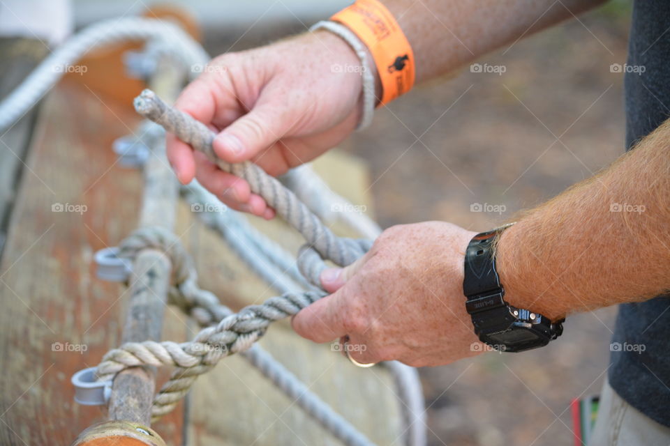 Rope Challenges. Man practices tying knots.