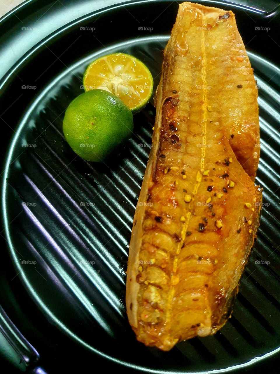 Grilled Stingray garnished with Chili Flakes, Garlic and Pepper