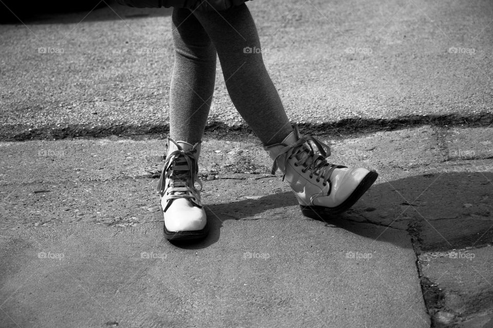 Young girl dancing outdoors. Wearing leather boots