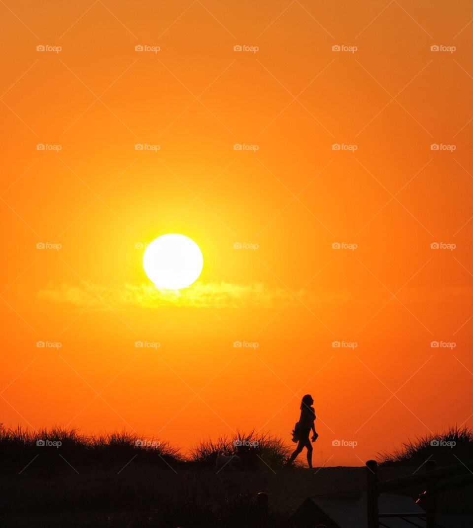 Silhouette of person walking in sanddune
