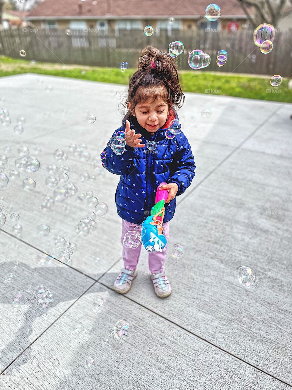 Toddler gets bubbles in her face, toddler girl playing with bubble maker outside blows too many bubbles, geometric shapes in everyday life, circular bubbles outside, blowing bubbles in the backyard, fun with bubbles and toddlers 