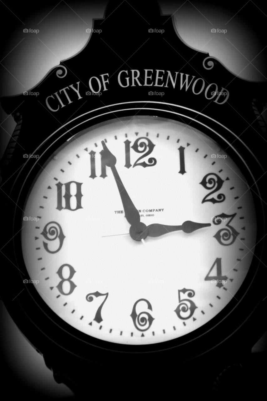 This is a up close picture of a town clock in downtown Greenwood done in black and white for character.
