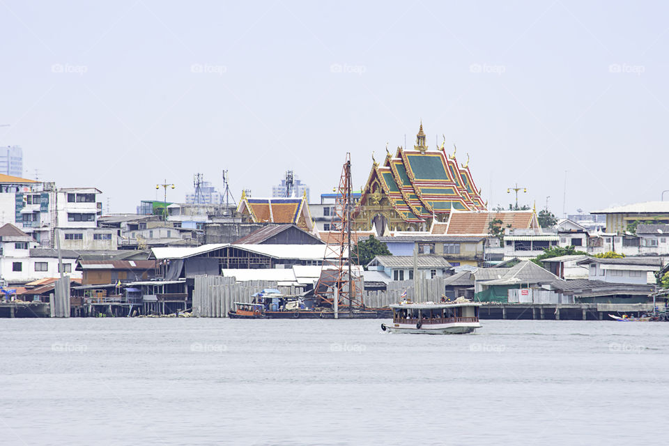 Ships crossing in Chao Phraya River and cityscape Background sky and clouds at Pak Kret in Nonthaburi , Thailand. April 16, 2019