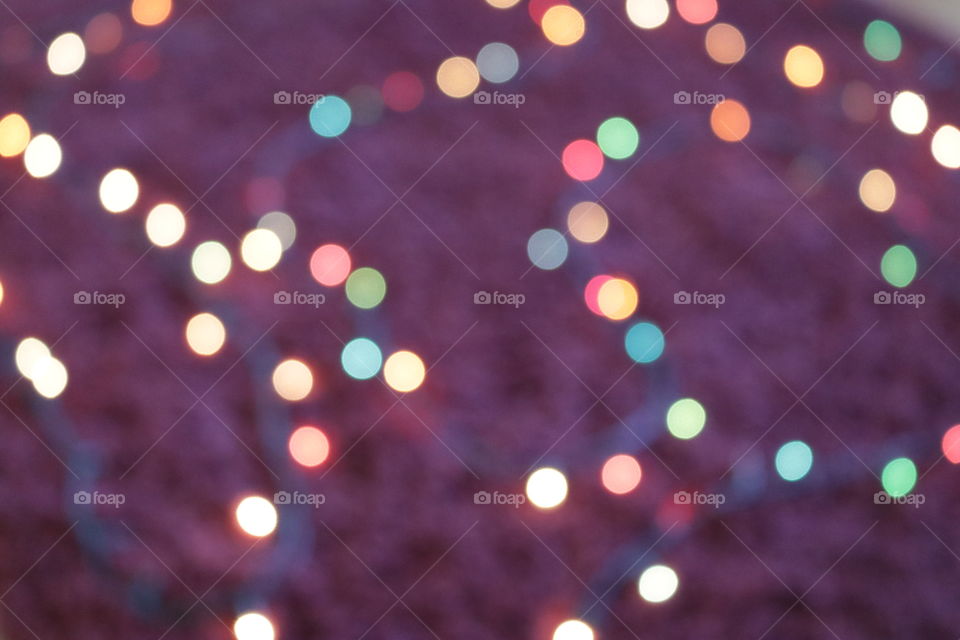 Colored bokeh of lights on a deep red background.