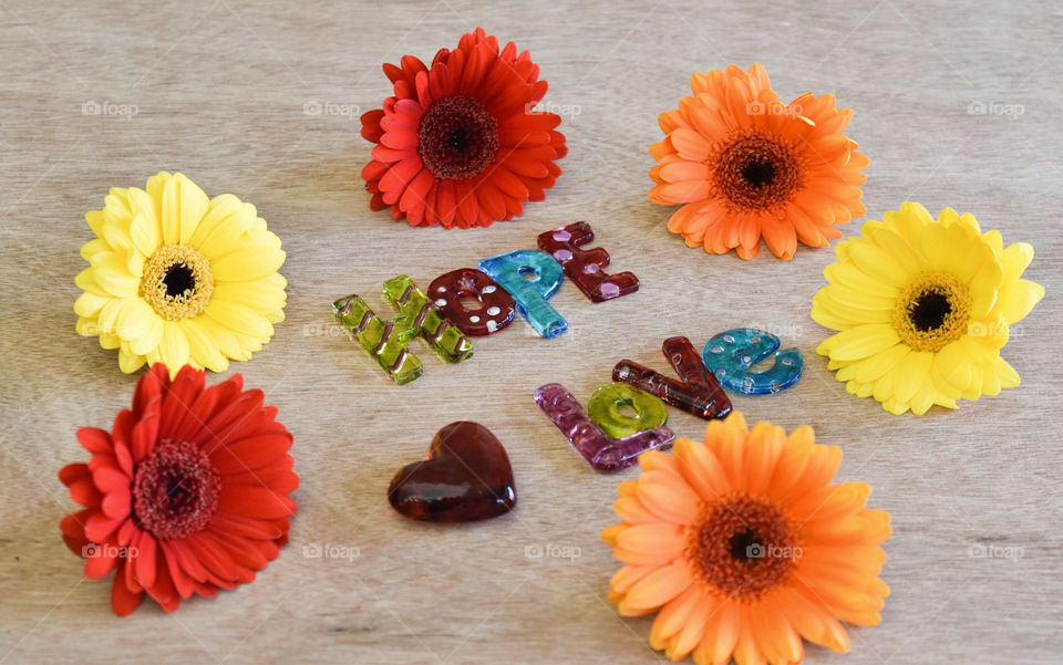 Art glass pieces spelling hope and love surrounded by colorful flowers