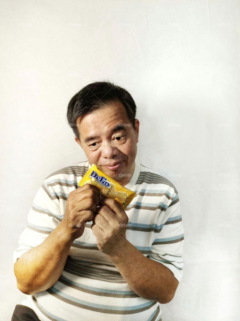 A Chinese man holding a candy bar.