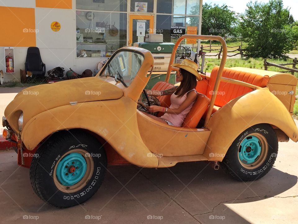 Woman sitting on vintage car