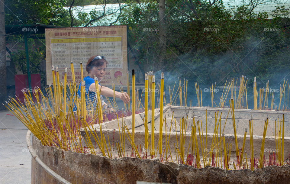 Woman offering incense. Photo taken in Hong Kong.