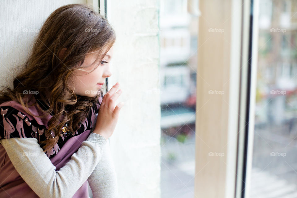 Teenage girl looking out of window