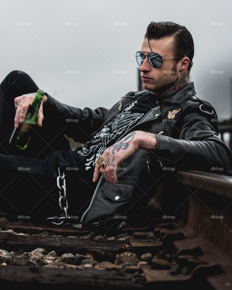 Man on railroad drinking a beer