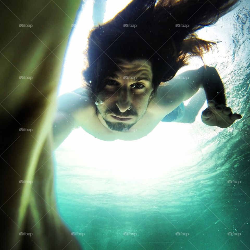 young man diving and looking at camera