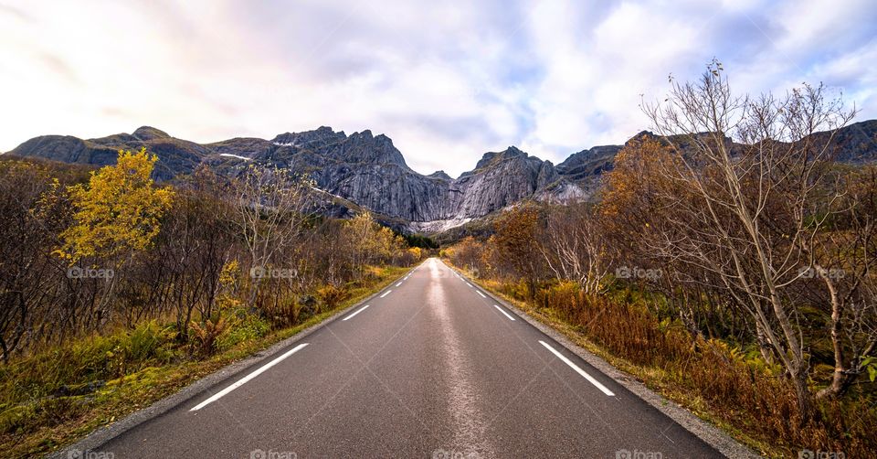 Empty road leading towards rock mountains
